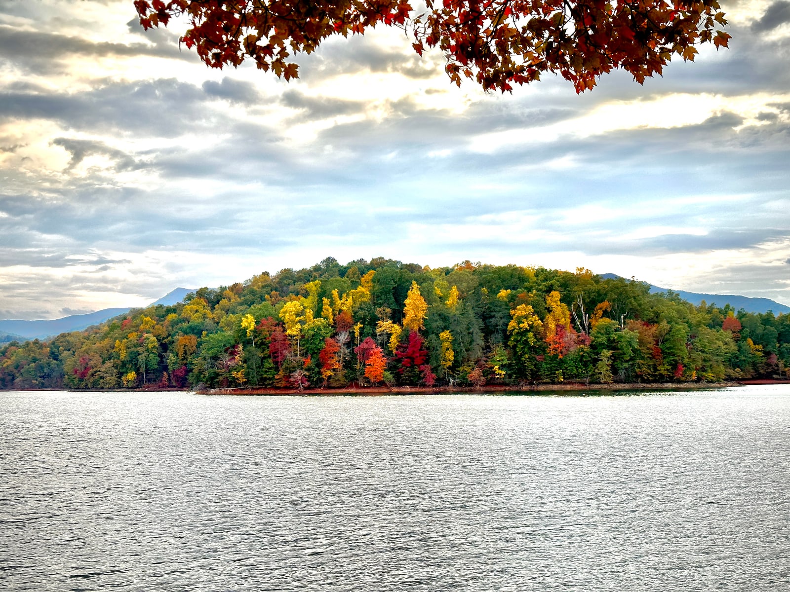 Brilliant fall foliage across the water in the North Georgia mountains