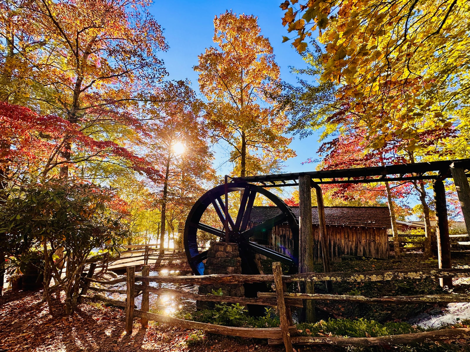 Historic waterwheel among brilliant autumn trees