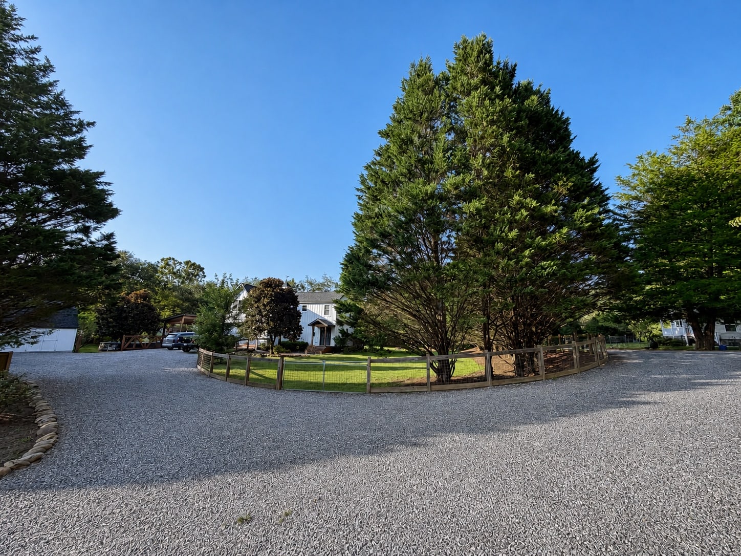 Long driveway view across the fenced property toward the home