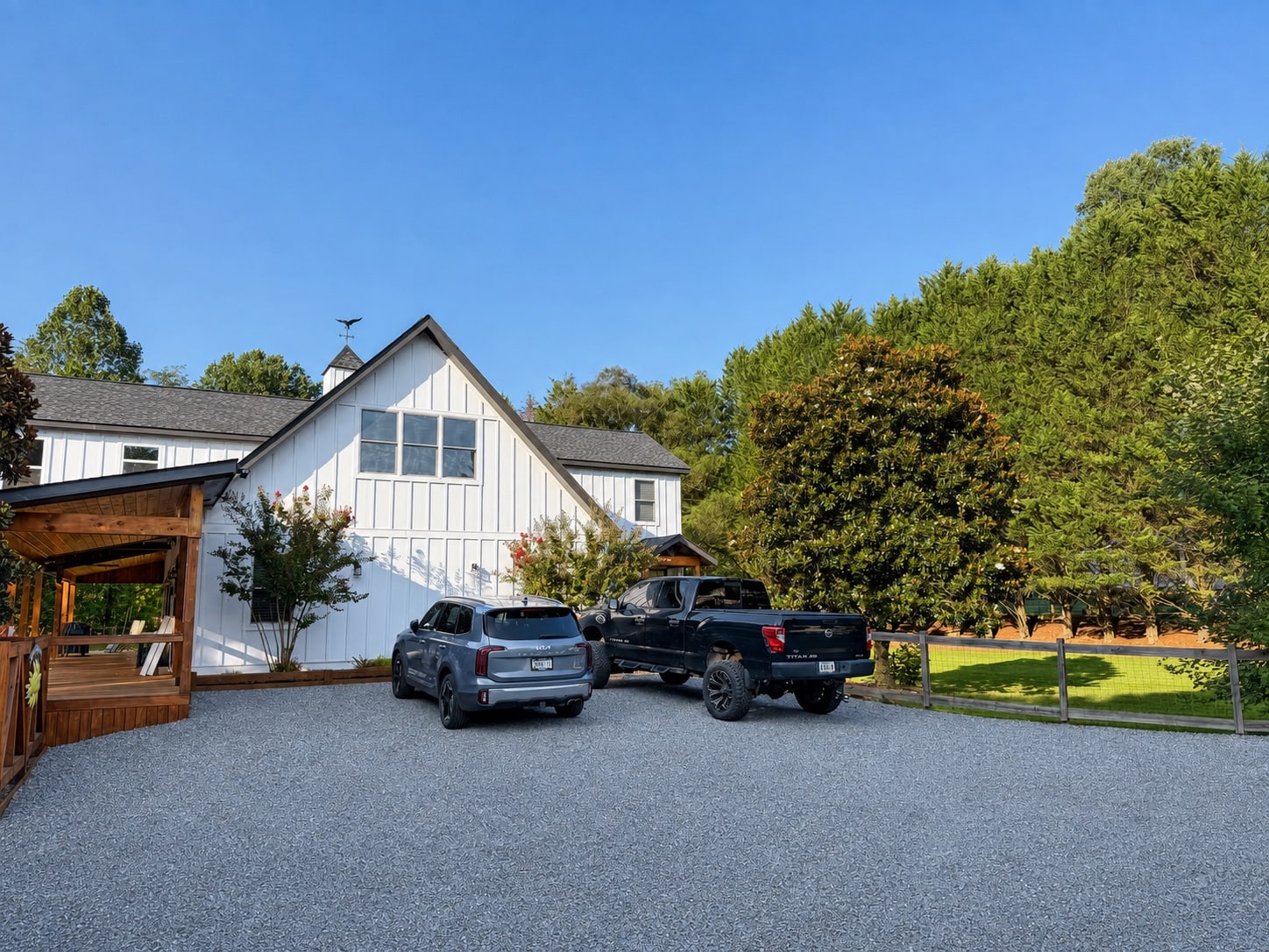 Side and rear of the home with gravel parking and covered porch