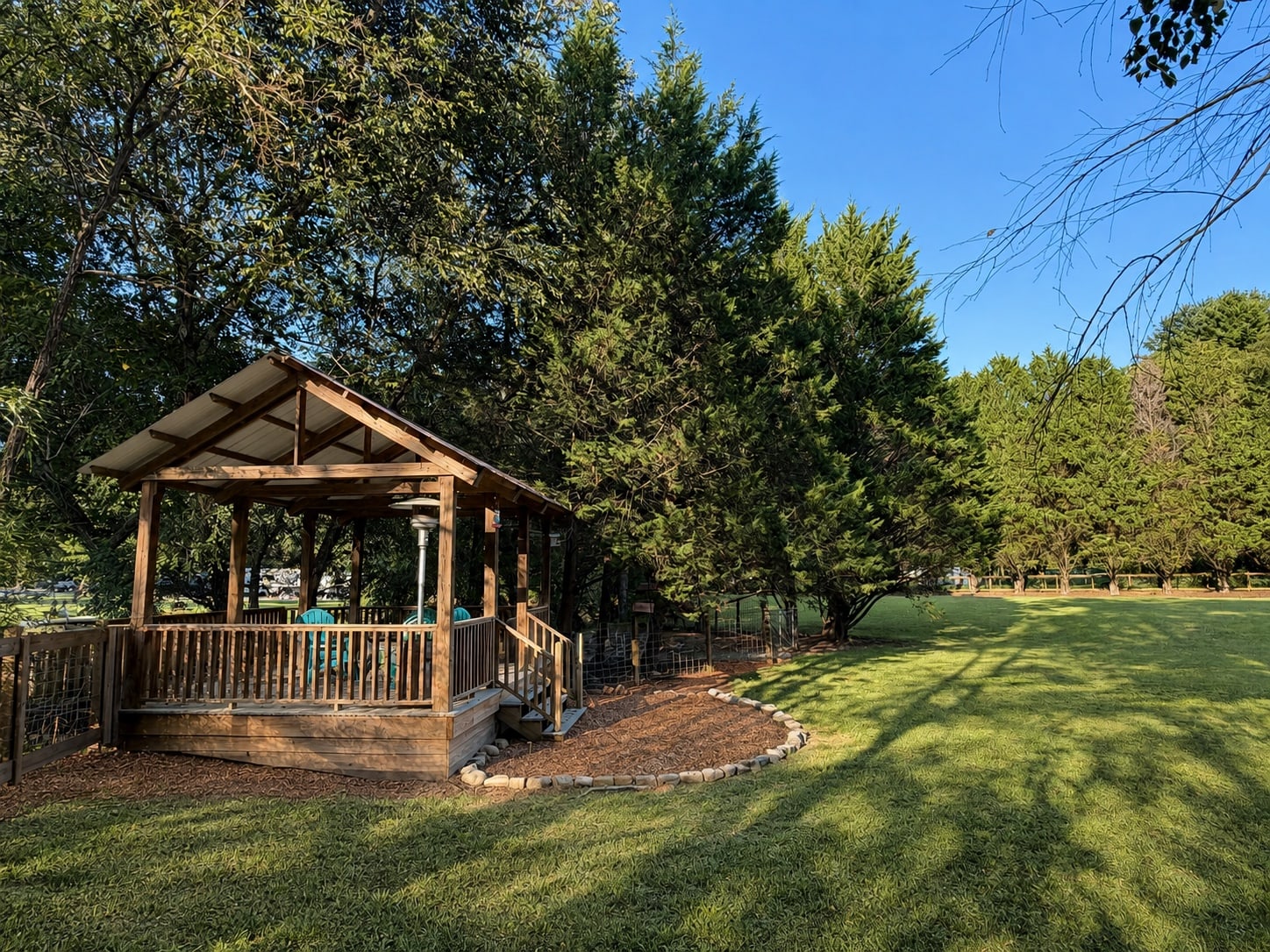 Wooden gazebo standing beside the property's large lawn