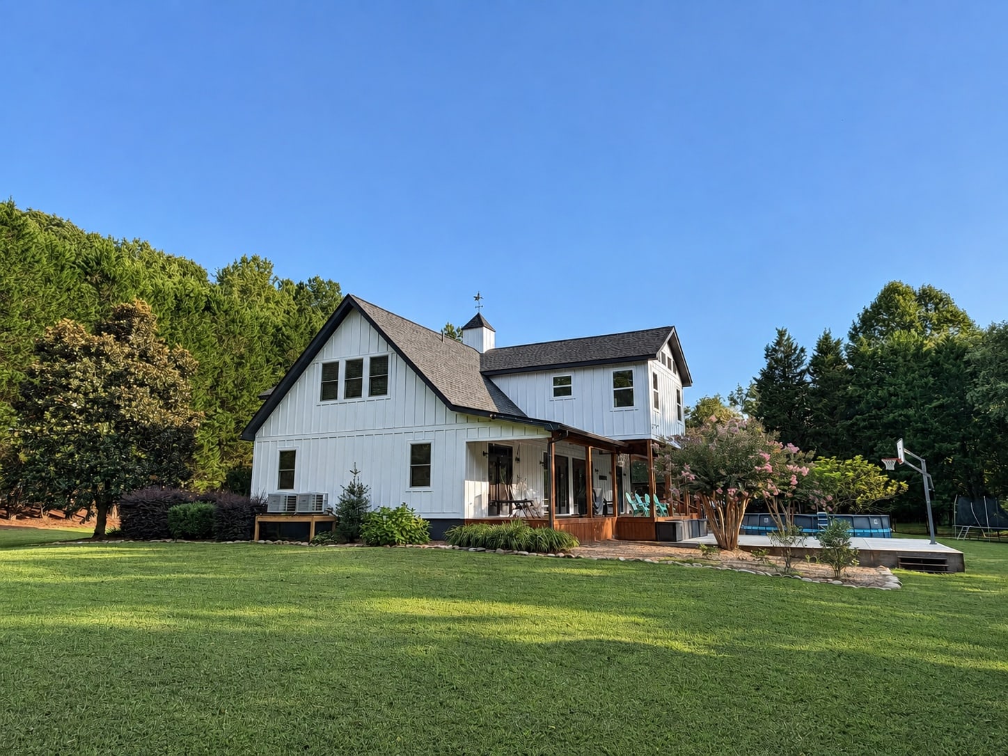 Rear and side elevation with covered porch, pool, and basketball hoop