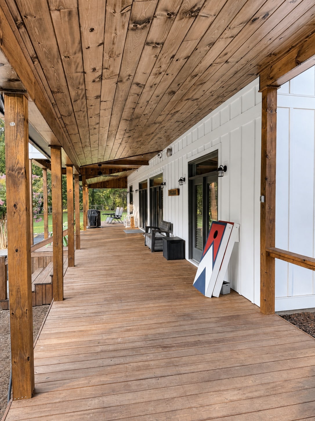 Long covered porch with wood ceiling and outdoor seating