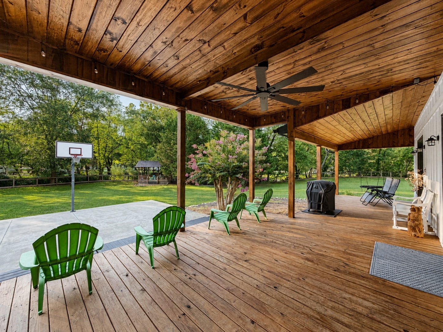 Covered porch seating overlooking the lawn and basketball court