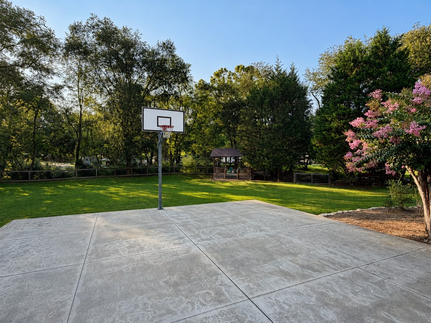 Private basketball court with gazebo and lawn beyond