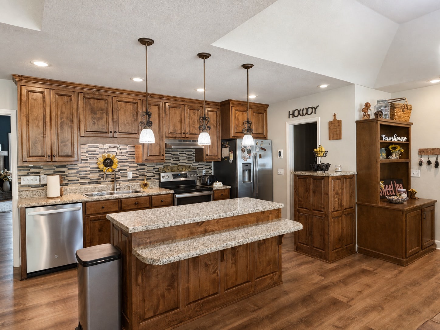 Kitchen with wood cabinetry, granite counters, island, and stainless appliances