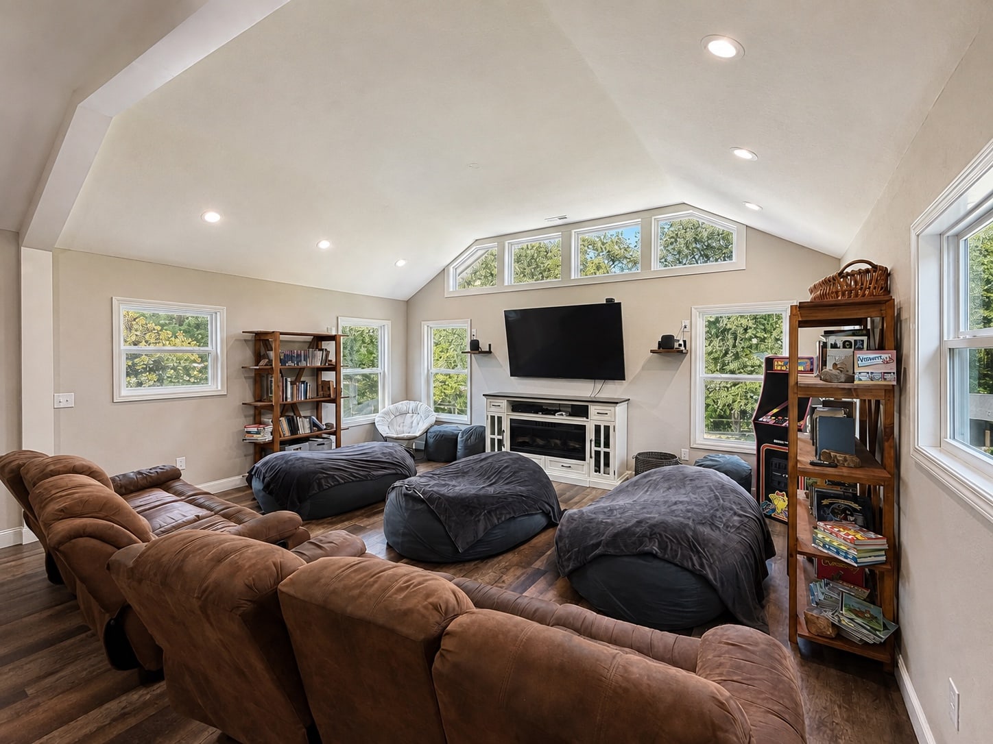 Media lounge with television, recliners, beanbag chairs, and arcade cabinet