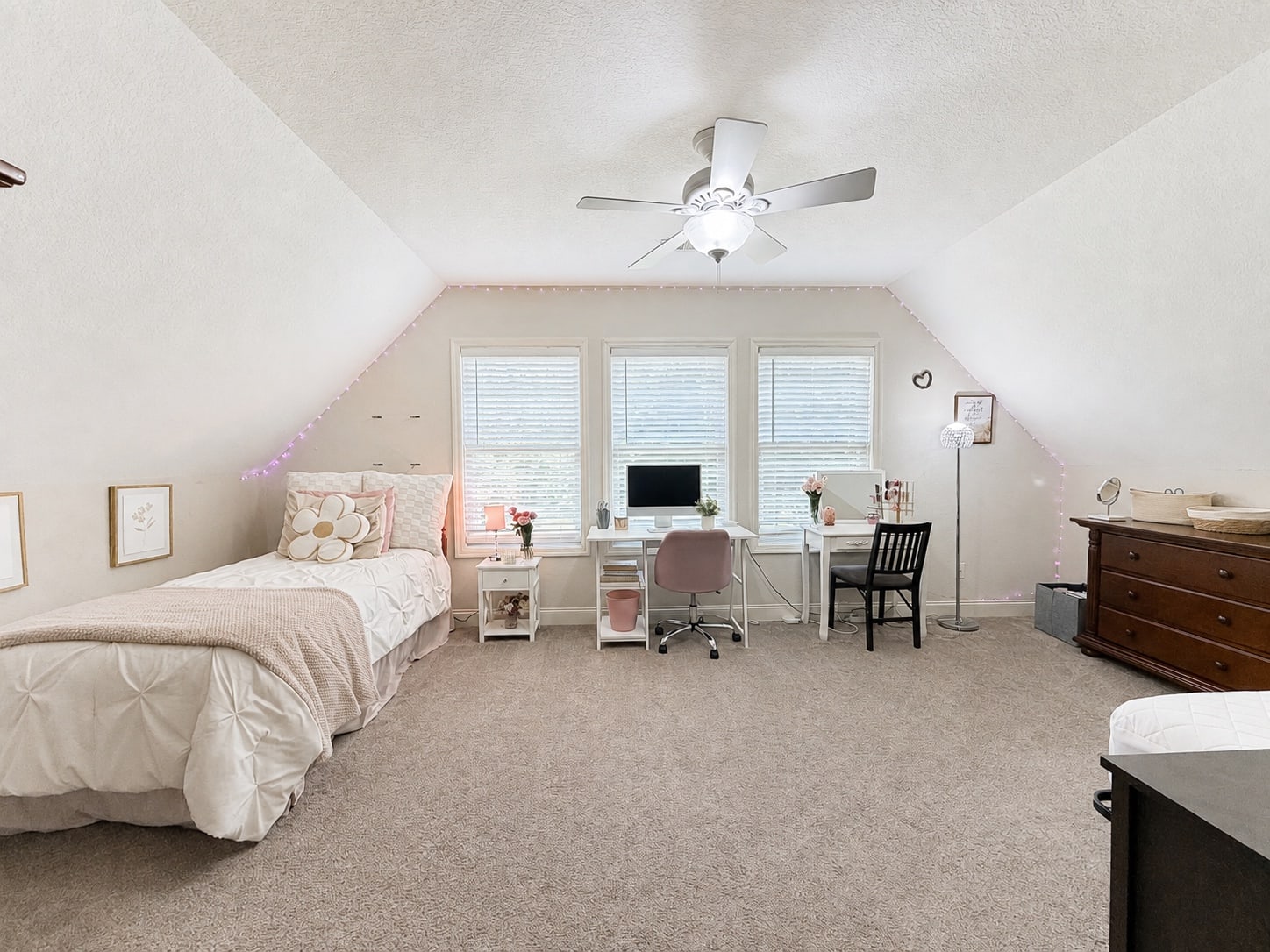 Bright bedroom with bed, desk, and generous open floor space