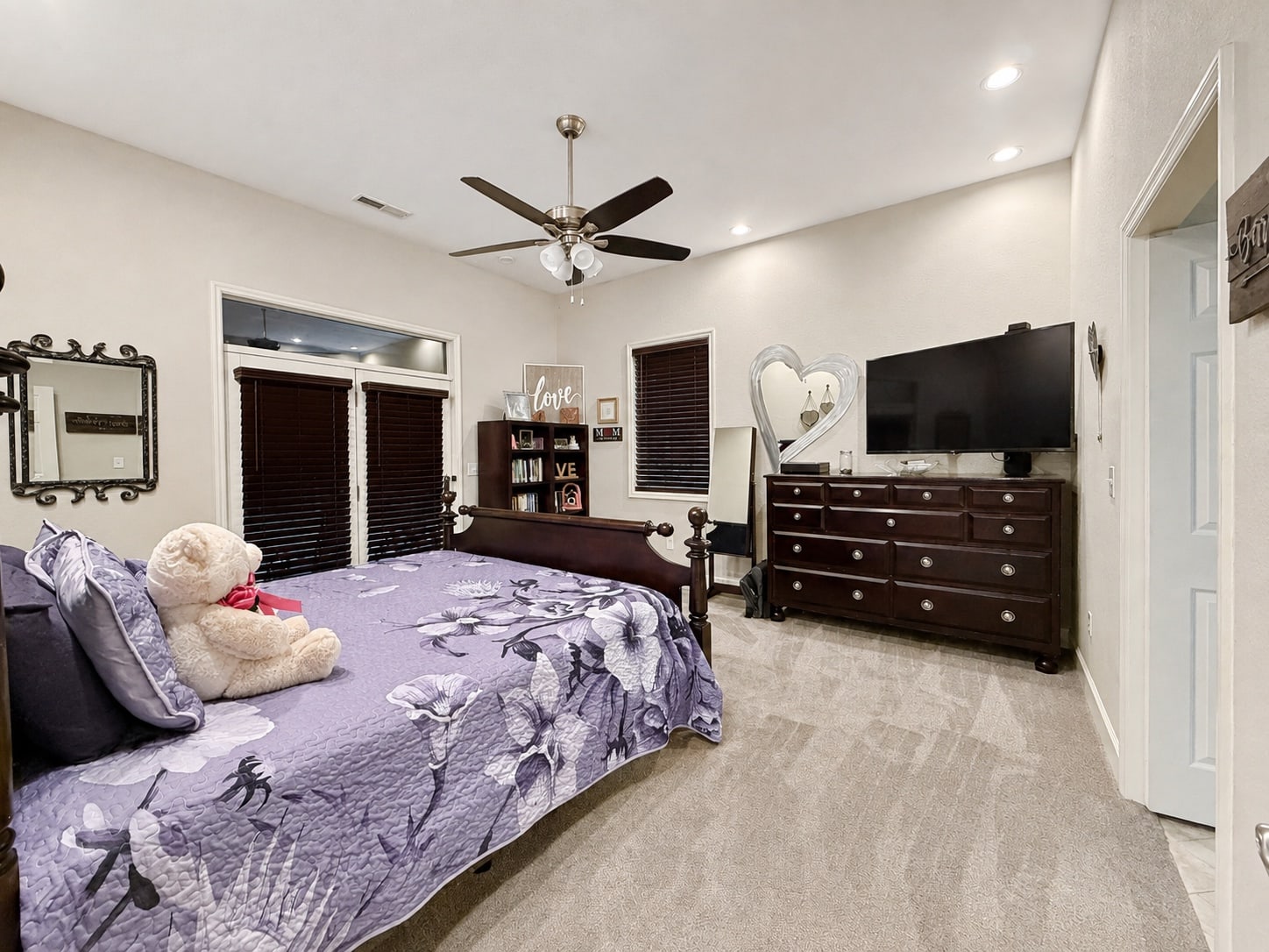 Carpeted bedroom with dark wood furniture and adjoining bathroom